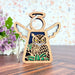 The Mother's Angels® Owl Ornament by Forged Flare® is a beautifully crafted wooden angel figurine, measuring 3.5 inches. It features intricate cutouts and showcases an owl perched on greenery. The ornament has elegant white wings and includes a string for hanging. The background design consists of a floral arrangement with purple flowers against a speckled pastel wall pattern, making it an excellent gift for bird lovers or as an owl ornament.