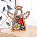 A beautiful Strawberry Ornament from Forged Flare®'s Mother's Angels® collection sits on a light-colored wooden surface. This 3.5" wooden angel figurine showcases a red strawberry, green leaves, and a white flower. A piece of braided linen string is attached to the top for easy hanging, making it an enchanting addition to your Christmas tree ornament collection or a unique gift idea for women.