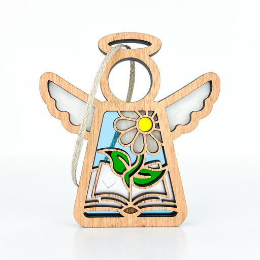 The Book Lovers Ornament by Forged Flare®, part of the Mother's Angels® collection, is a 3.5" wooden angel figurine with open wings and a halo. Featuring a daisy and leaves design with an open book at the base, this ornament has white accents on the wings, a blue background, and a braided linen string at the top for hanging—perfect as both a Christmas tree ornament and a book club gift.