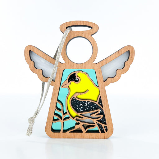 The Goldfinch Ornament by Forged Flare® showcases a 3.5" angel figurine from the Mother's Angels® collection, featuring a vivid yellow and black goldfinch perched on a branch. Set against a light blue background on the angel's body with wings and halo in natural wood color, this charming ornament includes a string for hanging, making it an ideal gift for bird lovers.
