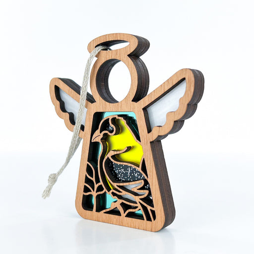 The Goldfinch Ornament | 3.5" Angel Figurine by Forged Flare® features a wooden angel ornament with wings and a string for hanging. The body of the angel is adorned with a vibrant design depicting a bird in nature, showcasing shades of yellow, green, and blue. A perfect gift for bird lovers, this Mother's Angels® piece stands out beautifully against a plain white background.
