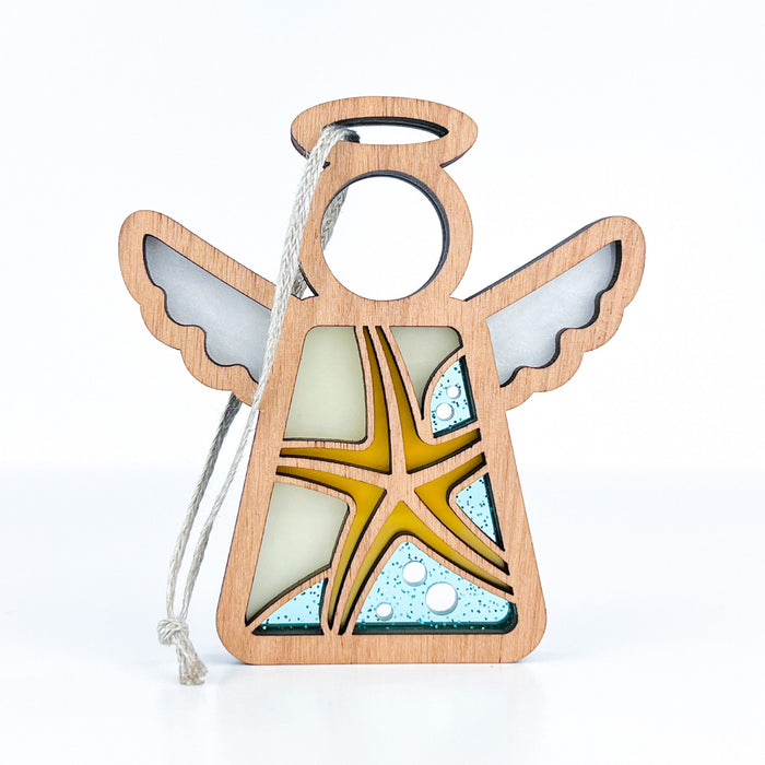 The Starfish Ornament | 3.5" Angel Figurine from Forged Flare®'s Mother's Angels® collection features a wooden angel figurine with a starfish design on its body, outlined in wood and filled with blue, yellow, and white wings, halo, and starfish. A string is attached for easy hanging on your Christmas tree.