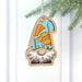 This delightful California Poppy Ornament, part of the Nature's Gnomes™ collection by Forged Flare®, features a 3.75" garden gnome wearing a blue hat decorated with orange poppy flowers. It is elegantly displayed hanging from a green Christmas tree branch against a clean white background.