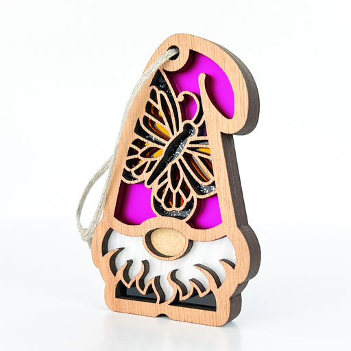 Part of the Nature’s Gnomes™ collection by Forged Flare®, the Monarch Butterfly Ornament is a 3.75" garden gnome gift that features a detailed cutout design. The wooden gnome's hat is adorned with a Monarch butterfly showcasing yellow and black wings against a vibrant pink background. With its white beard, small round nose, and string for hanging, this enchanting ornament adds charm to any garden decor.