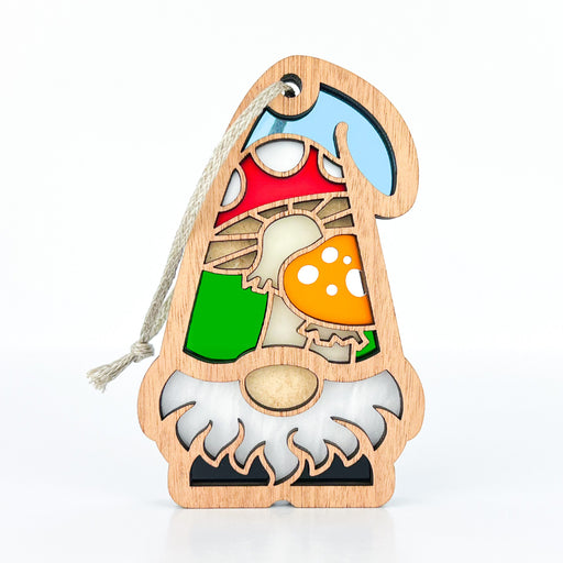 Introducing the Toadstool Mushroom Ornament, a 3.75" garden gnome gift from Forged Flare's Nature's Gnomes™ collection. This charming wooden ornament features a whimsical garden gnome with a blue hat and white beard, and is adorned with colorful sections in red, green, yellow, and orange forming a toadstool mushroom and other playful patterns. It also comes with an attached string for easy hanging.