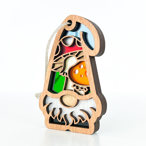 Part of Forged Flare's® Nature’s Gnomes™ collection, the Toadstool Mushroom Ornament (3.75" Garden Gnome Gift) features a charming wooden gnome with a toadstool hat and vibrant inlaid sections in red, blue, green, and orange. A string loop at the top allows for easy hanging, making it a whimsical addition to your decor.